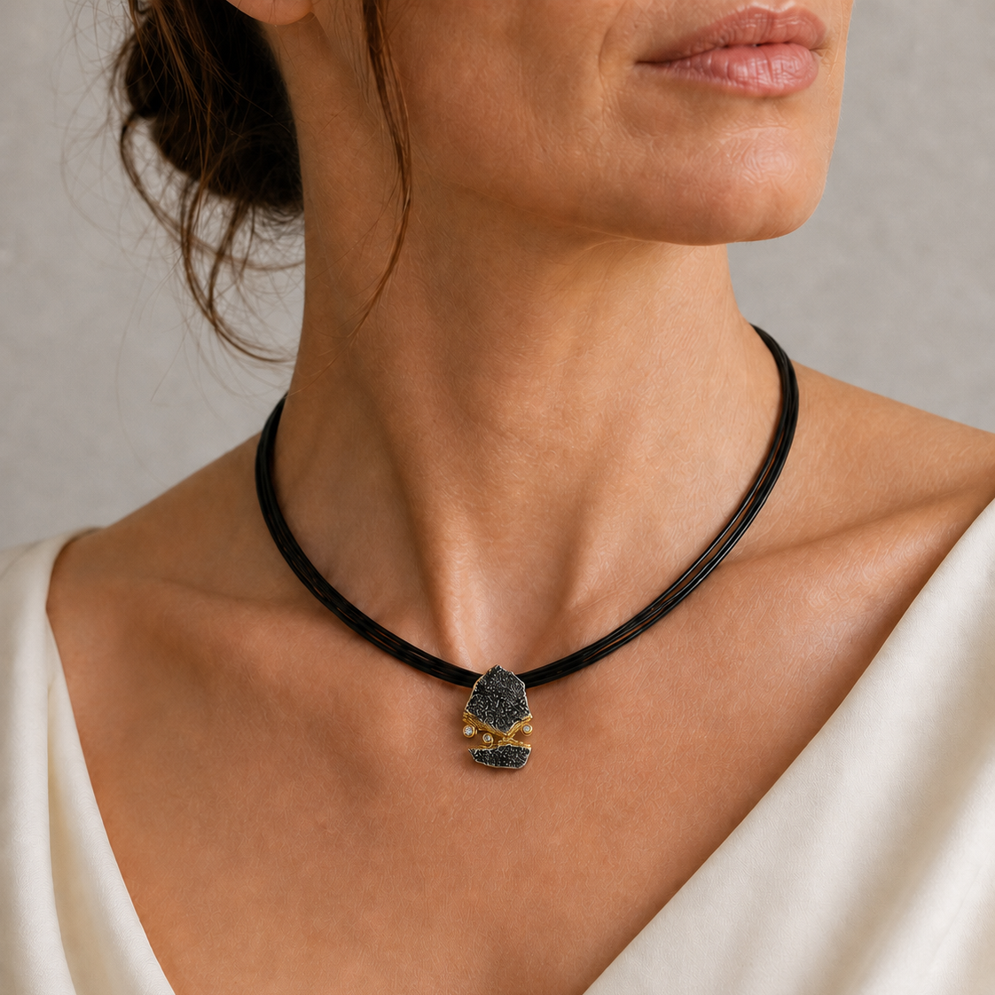 | Bild 1 – Hauptbild, Dekolleté | `fels-anhaenger-weisser-saphir-model-dekollete.jpg` | Model trägt den FELS Anhänger aus oxidiertem 925er Silber mit Goldakzenten und weißen Saphiren. 