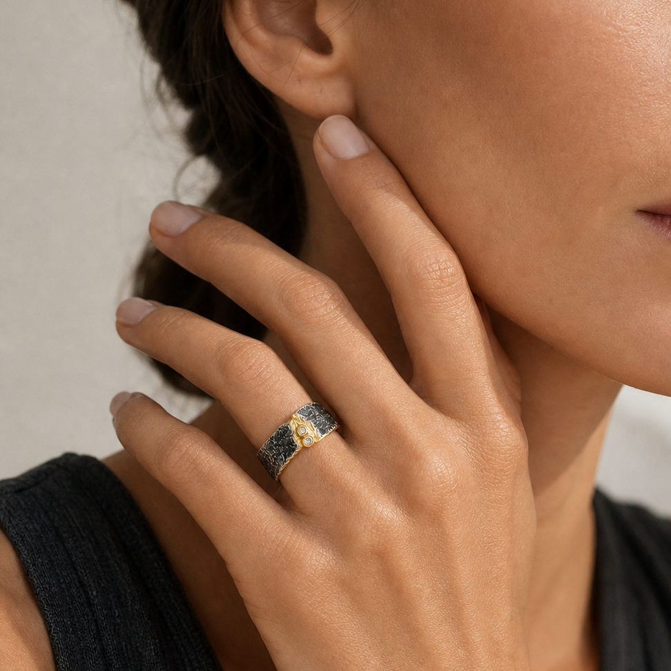 Nahaufnahme einer Frau mit dem breiten FELS Ring aus oxidiertem Silber, Gold und weißen Saphiren.