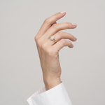 Ring W0037 aus 585er Gelbgold mit Labordiamant – an der angehobenen Hand mit weißer Manschette