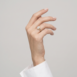 Ring W0037 aus 585er Gelbgold mit Labordiamant – an der angehobenen Hand mit weißer Manschette