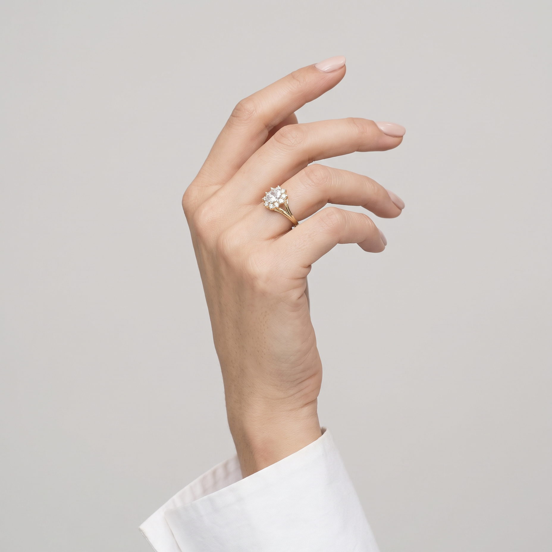 Ring W0037 aus 585er Gelbgold mit Labordiamant – an der angehobenen Hand mit weißer Manschette
