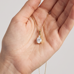 Anhänger Z0001 aus 585er Gelbgold mit Labordiamant – in der geöffneten Hand zur hellblauen Bluse