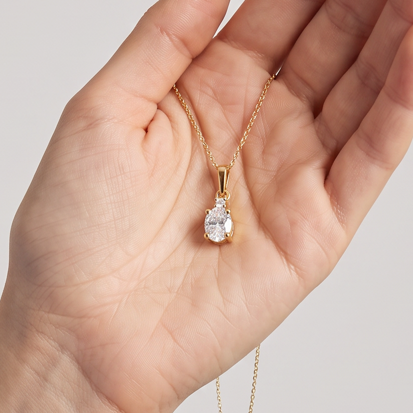 Anhänger Z0001 aus 585er Gelbgold mit Labordiamant – in der geöffneten Hand zur hellblauen Bluse