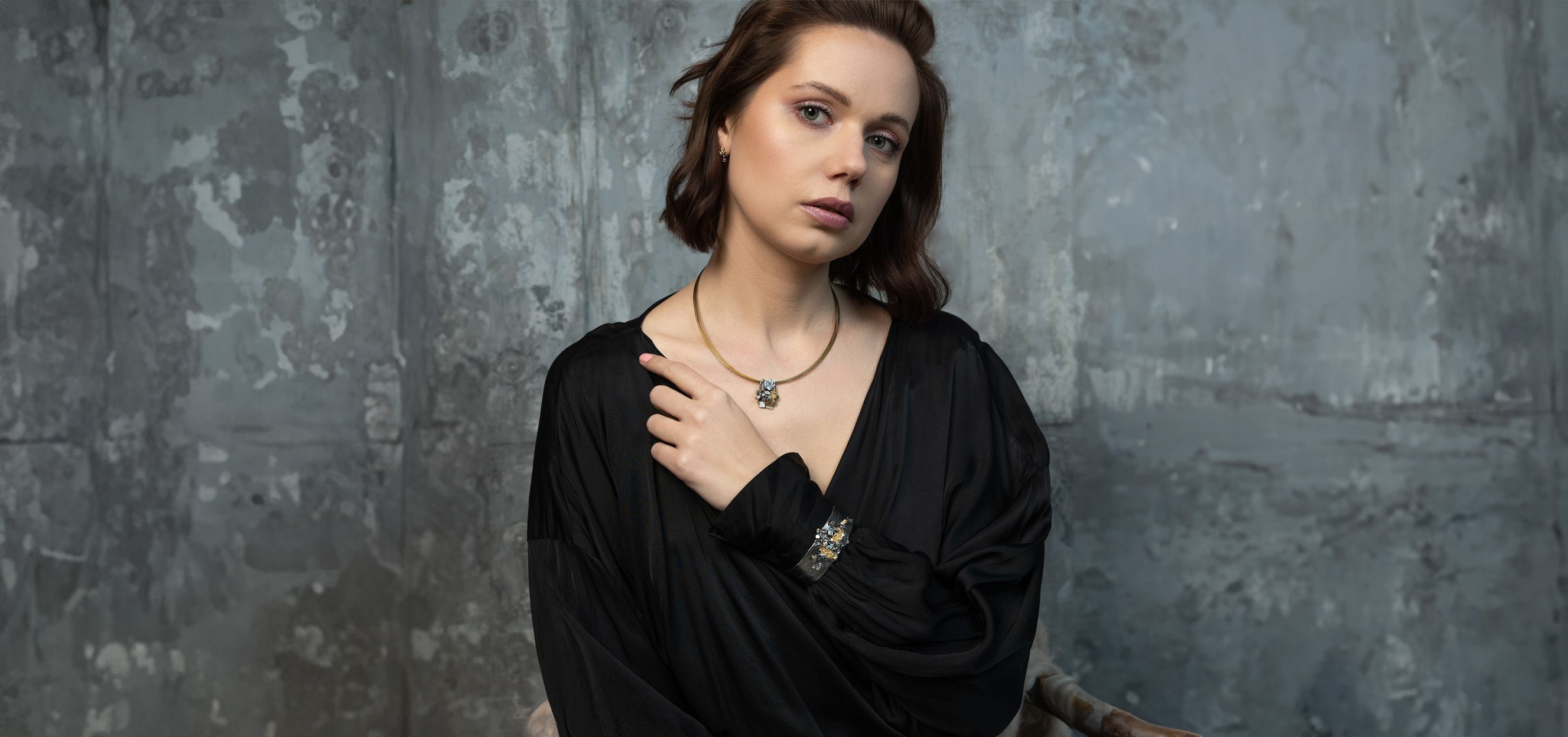 Hauptfoto-brünette Frau mit schönem Armband, Auf einem grauen Stein Hintergrund